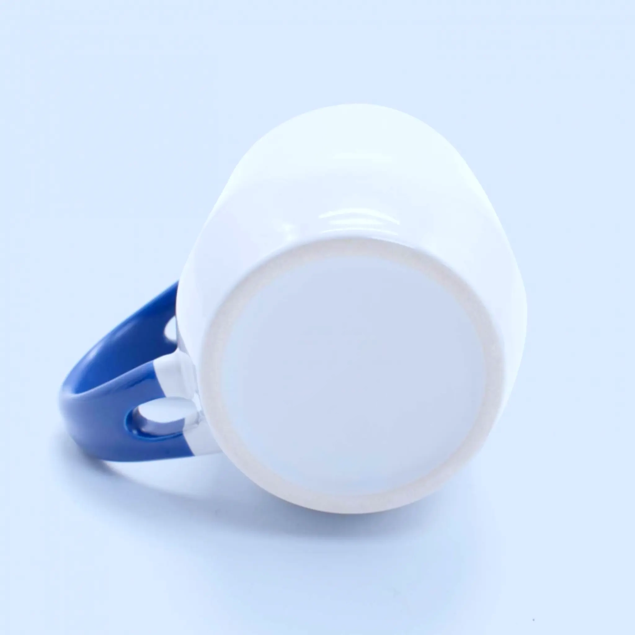 Base del tazón con cuchara azul personalizado, detalle de cerámica blanca.