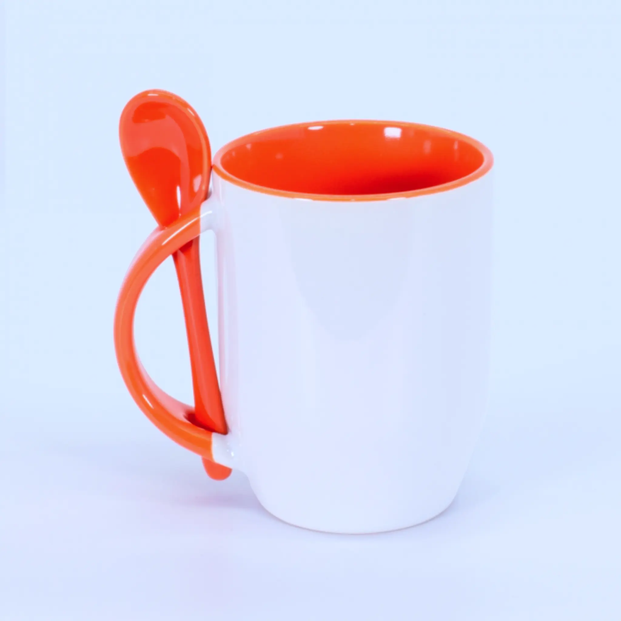 Tazón con cuchara naranjo sin diseño impreso, fondo blanco.